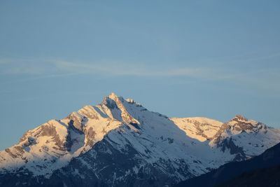 Low angle view of snowcapped mountains against sky