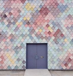 Closed entrance door amidst pattern wall of building