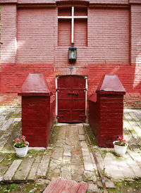 Red door on footpath against building