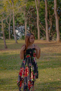 Woman standing by tree on field