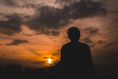 Silhouette man standing against orange sky