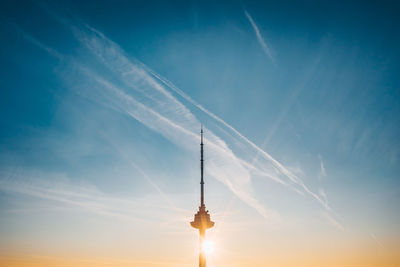 Low angle view of illuminated tower against blue sky