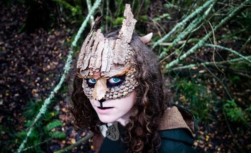 Portrait of young woman wearing mask in forest