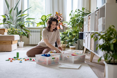 Portrait of young woman sitting on table at home