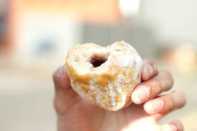 Cropped image of hand holding sweet food