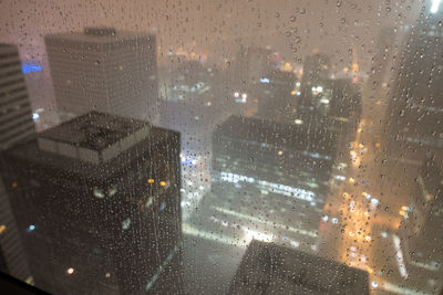 Aerial view of city street seen through wet glass window
