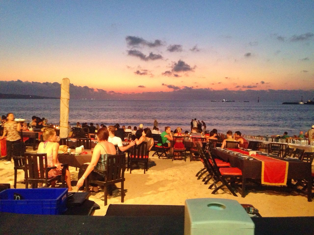 sea, water, horizon over water, chair, beach, sky, table, sunset, lounge chair, scenics, relaxation, vacations, restaurant, shore, sunlight, nature, deck chair, person, tranquil scene, beauty in nature