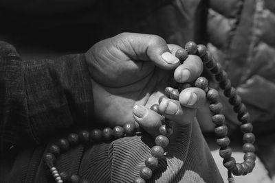 Cropped hand holding prayer beads