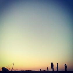 View of people against clear sky at sunset