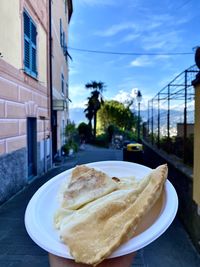 Close-up of food on table in city against sky