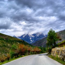 Surface level of country road against cloudy sky