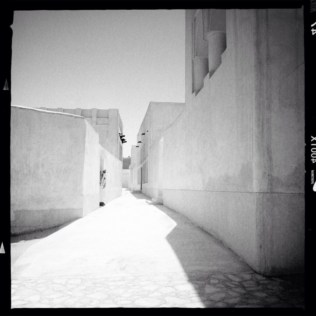 architecture, built structure, the way forward, transfer print, building exterior, diminishing perspective, auto post production filter, narrow, walkway, empty, corridor, building, vanishing point, long, alley, wall - building feature, residential structure, clear sky, sunlight, cobblestone