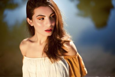 Beautiful woman standing against lake