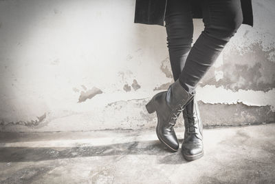 Low section of woman standing against wall