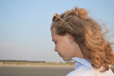 Portrait of beautiful young woman against sky