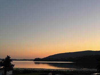 Scenic view of lake against clear sky during sunset