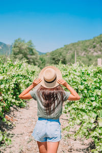 Rear view of woman wearing hat standing against sky