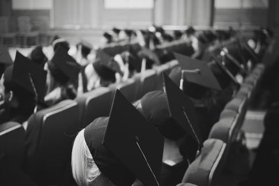 Students wearing mortarboards while sitting in auditorium