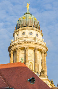 Low angle view of french cathedral against blue sky at gendarmenmarkt, berlin, germany