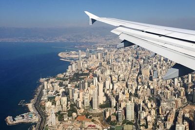 Airplane wing over cityscape