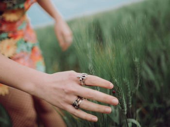 Midsection of woman touching plant