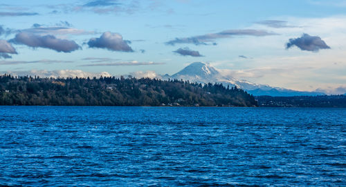 Scenic view of sea and snowcapped mountains against sky