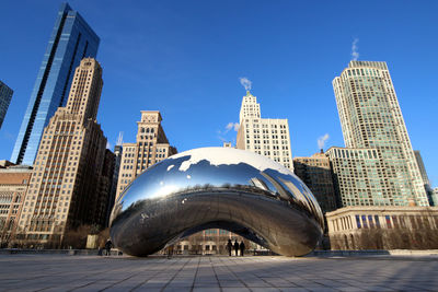 Low angle view of skyscrapers against blue sky