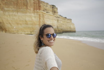 Portrait of smiling woman standing at beach