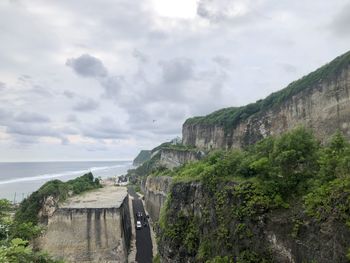 Scenic view of cliff by sea against sky