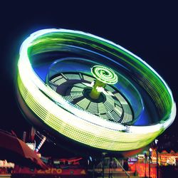 Low angle view of illuminated ferris wheel against sky