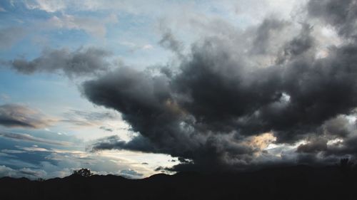 Silhouette of landscape against cloudy sky