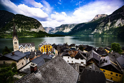 High angle view of houses by lake and buildings against sky