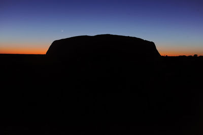 Silhouette rock formation against clear sky during sunset