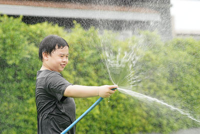 Boy play water with hose