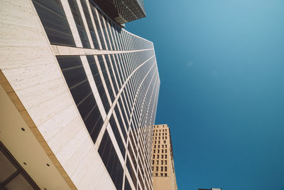 Low angle view of modern buildings against clear blue sky