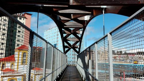 Footbridge against sky in city