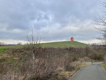 Road amidst field against sky