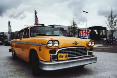 Vintage car on street against sky