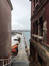 Staircase leading towards pier in sea against sky