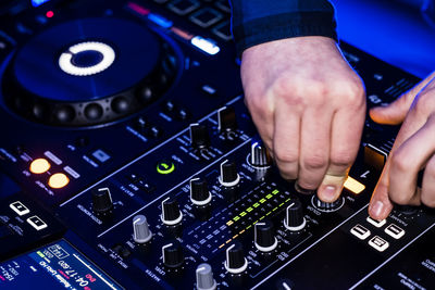 Cropped hands of man playing audio equipment