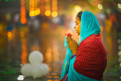 Side view of woman holding umbrella