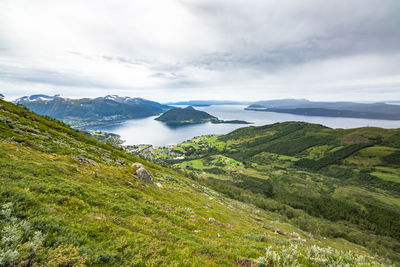 Scenic view of sea and mountains against sky