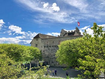 People at historical building against sky