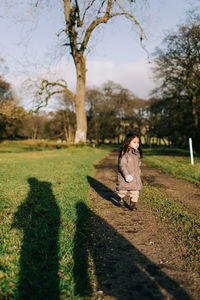 Girl standing on footpath at park during winter