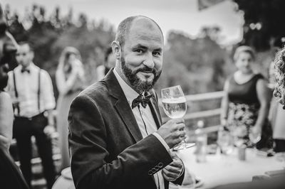 Portrait of smiling man holding alcoholic drink during party