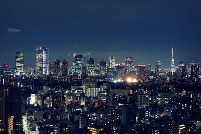 Illuminated cityscape against sky at night