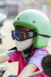 Close-up of girl wearing surgical mask and crash helmet