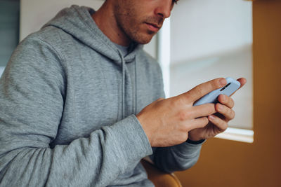 Midsection of man using mobile phone