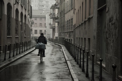 Rear view of woman walking on road in city