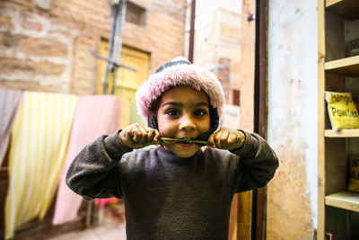 Portrait of boy standing against wall